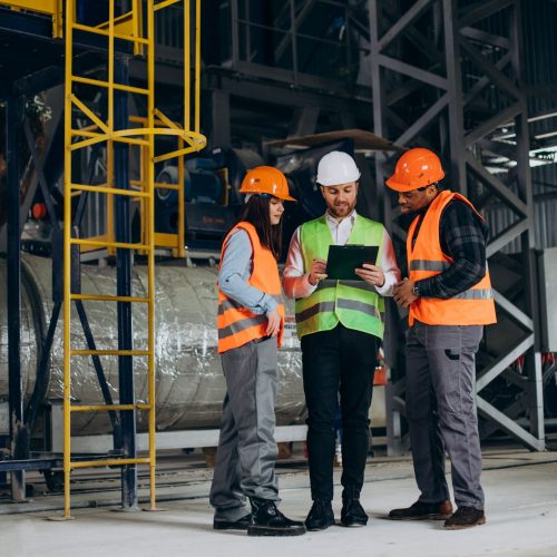 tres-trabajadores-fabrica-sombreros-seguridad-discutiendo-plan-fabricacion